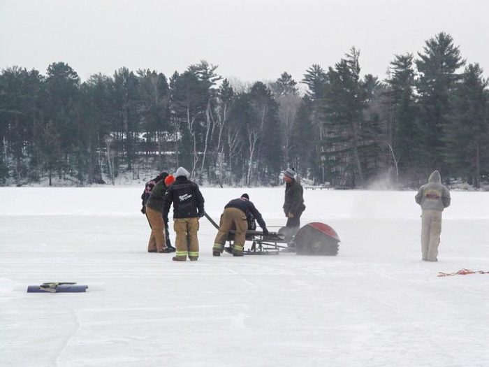 A group of people standing on a frozen lake.
