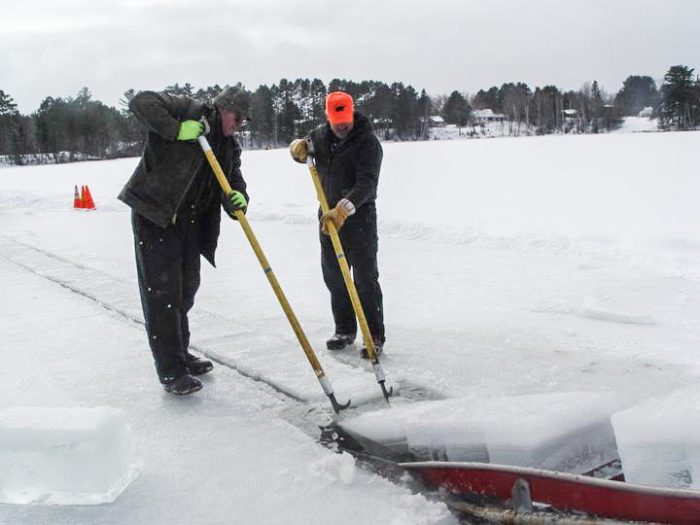 Two men ice fishing on a frozen lake.