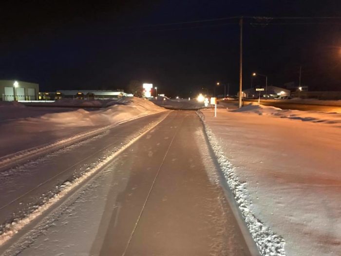 A road covered in snow at night.