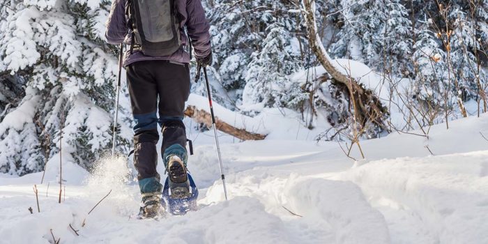 A person hiking in the snow with snowshoes.