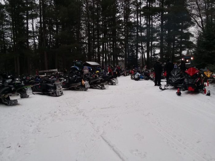 A group of snowmobiles parked in the snow.