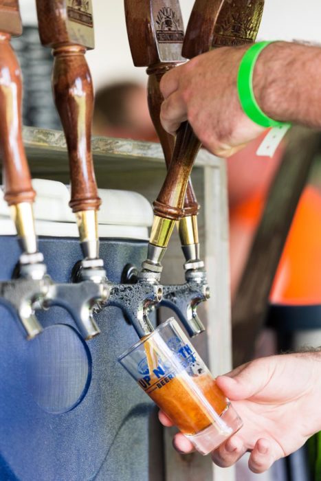 A person pouring a beer into a glass.