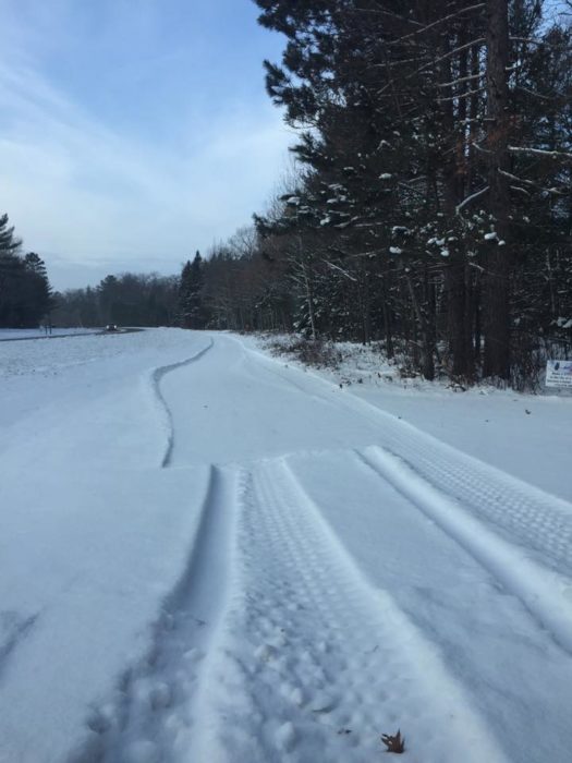 A snow covered trail with tracks in the snow.