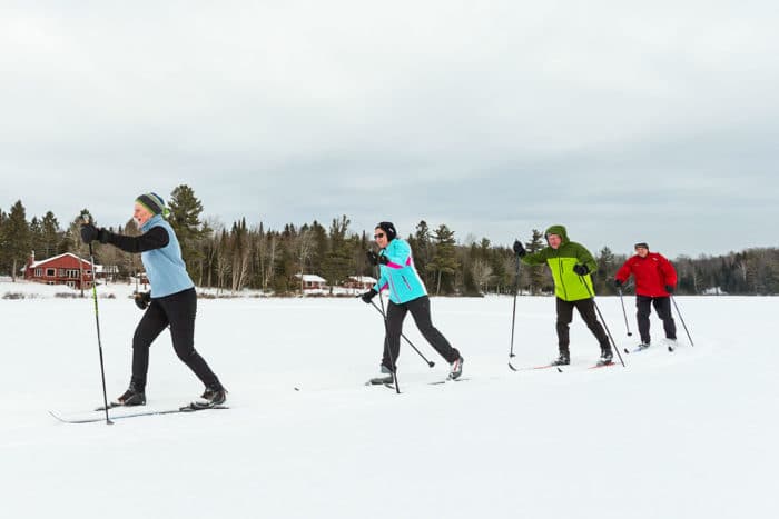 A group of people cross country skiing in the snow.