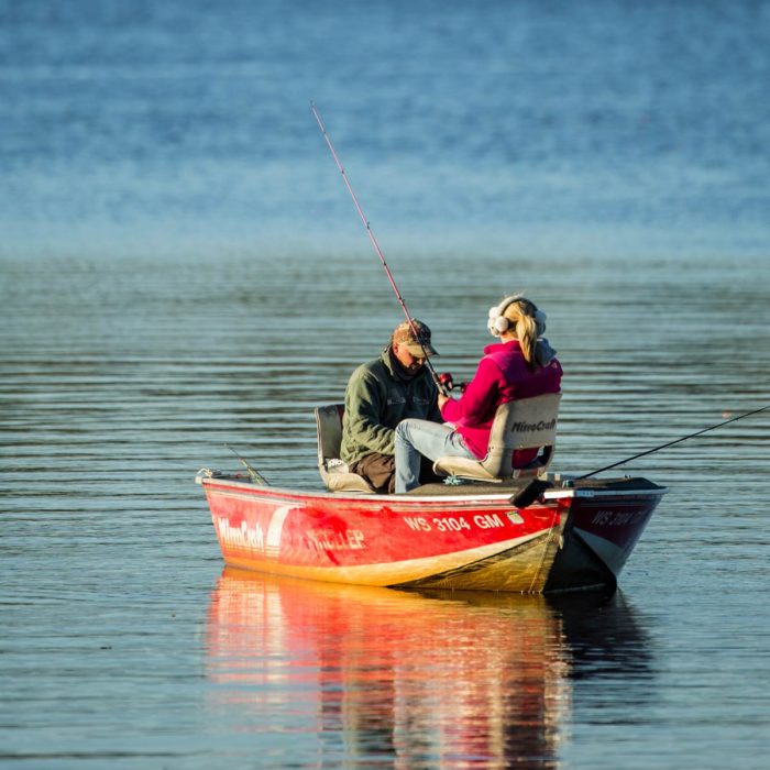 A man and woman fishing in a boat.