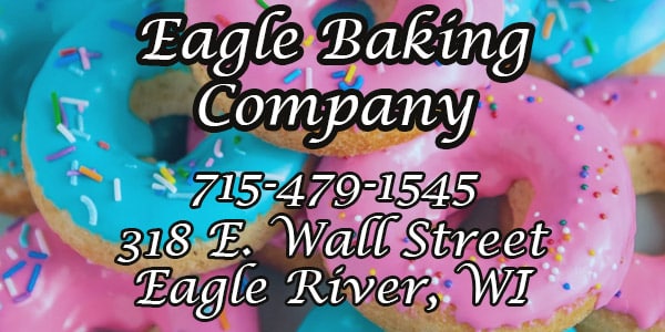 Colorful donuts with pink and blue icing and sprinkles form the background for text with the name, phone number, and address of Eagle Baking Company in Eagle River, WI.