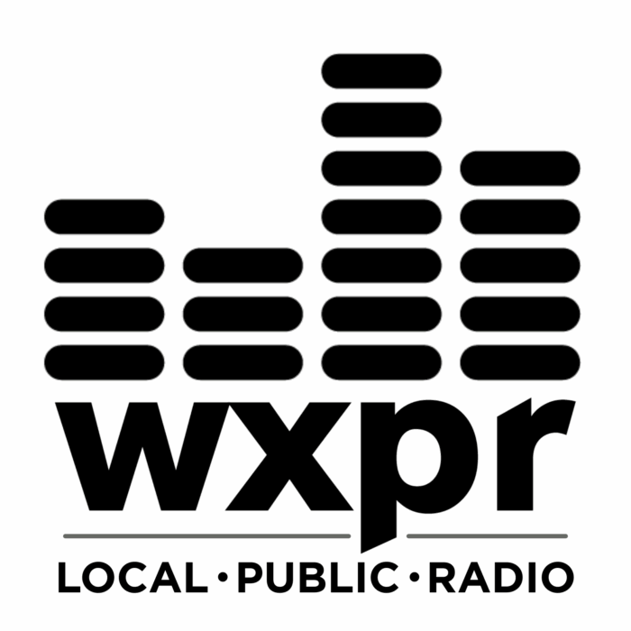 Black and white logo with stacked horizontal bars resembling sound waves above the letters "wxpr." Below, the words "LOCAL · PUBLIC · RADIO" appear in capital letters.