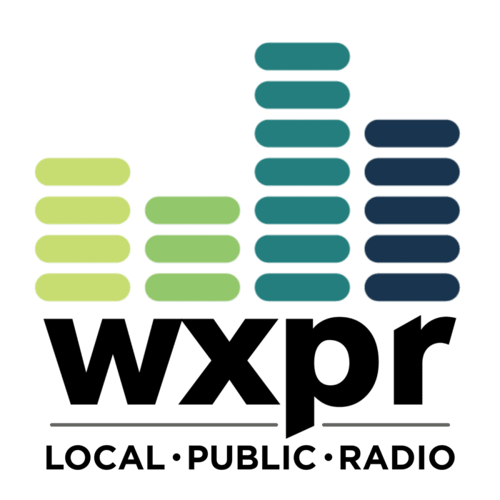 WXPR logo featuring green and blue bars resembling an equalizer above the text "wxpr" and "LOCAL · PUBLIC · RADIO" in black capital letters.