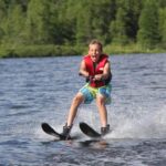 Young boy water skiing on lake
