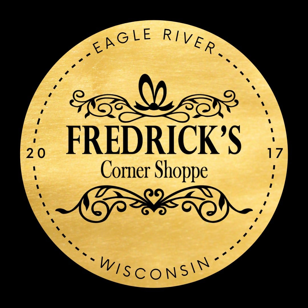 Gold circular logo for "Fredrick's Corner Shoppe," a charming boutique with decorative elements and text "Eagle River, Wisconsin" and "2017.