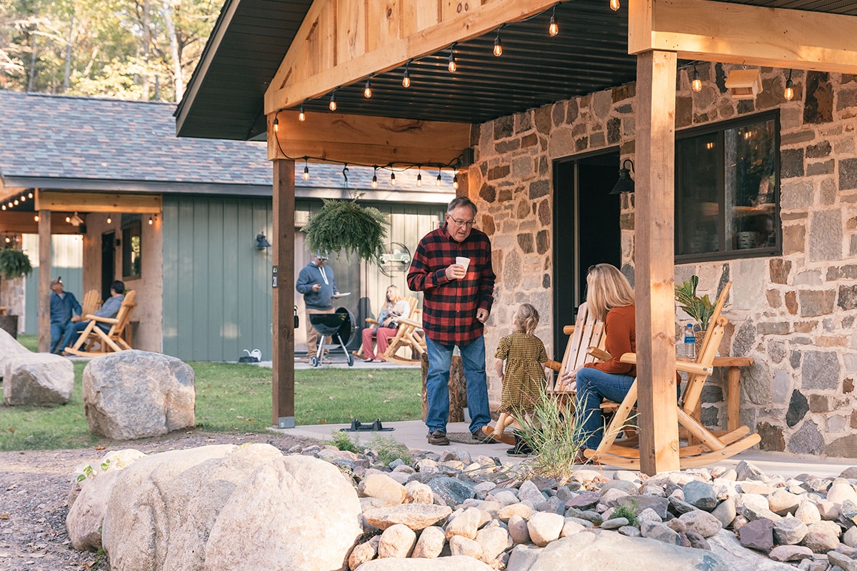 A family sits on the porch of a cabin.