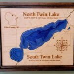 Wooden map of North and South Twin Lake in Vilas County, WI, showing lake depths and coordinates, with a compass rose for orientation.