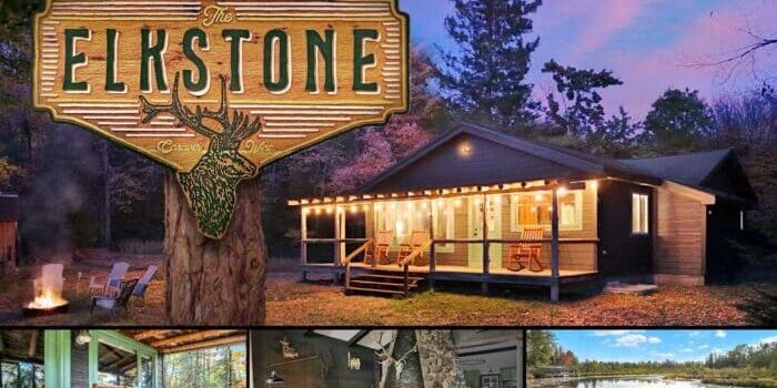 Rustic cabin surrounded by trees at dusk, featuring a porch with rocking chairs. Inset images show a cozy interior with a stone fireplace and a serene lake view. Sign reads "The Elkstone.