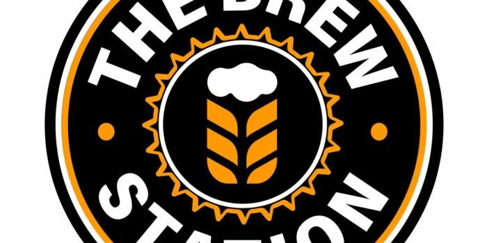 A circular logo for "The Brew Station" with a beer and wheat design in the center, surrounded by a black and orange border.