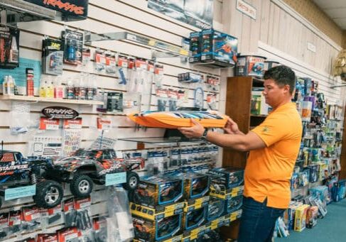 A man looking at toys in a toy store.