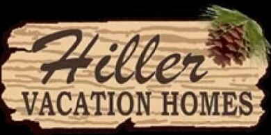 Sign reads "Hiller Vacation Homes" with a wood texture and a pinecone in the corner.