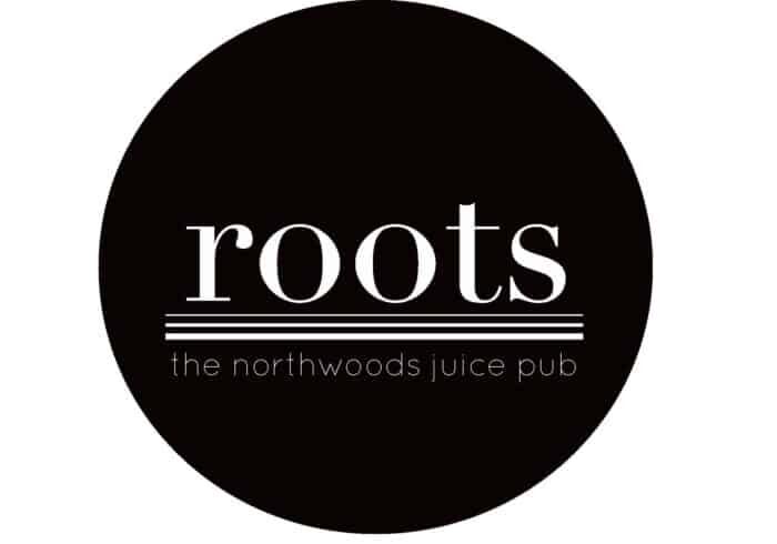Black circular logo with the word "roots" in large white letters above horizontal lines and the text "the northwoods juice pub" in smaller white letters below.