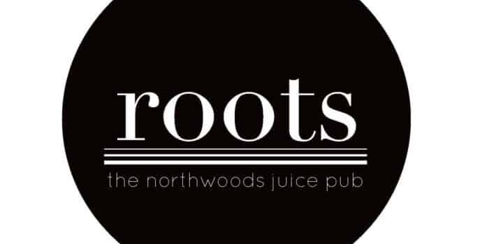 Black circular logo with the word "roots" in large white letters above horizontal lines and the text "the northwoods juice pub" in smaller white letters below.