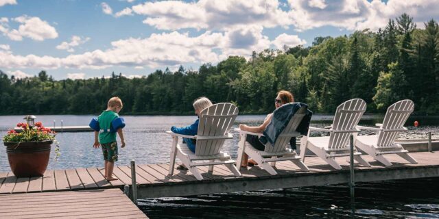 Family sitting on chairs along a lake on a sunny day