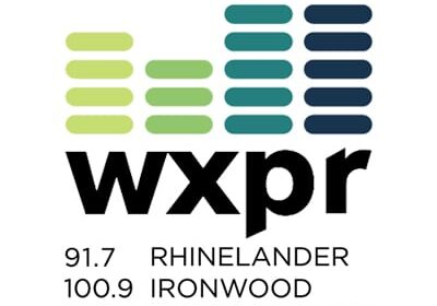 WXPR radio logo with horizontal bars in green and blue above the station name. Frequencies listed: 91.7 Rhinelander, 100.9 Ironwood, 91.9 Wausau. Website: WXPR.ORG.