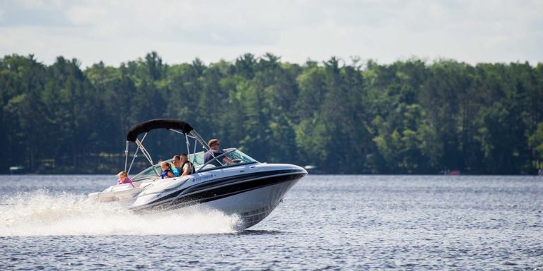 A group of people riding a speed boat on a lake.
