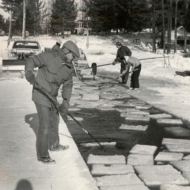 A group of people cleaning ice blocks.