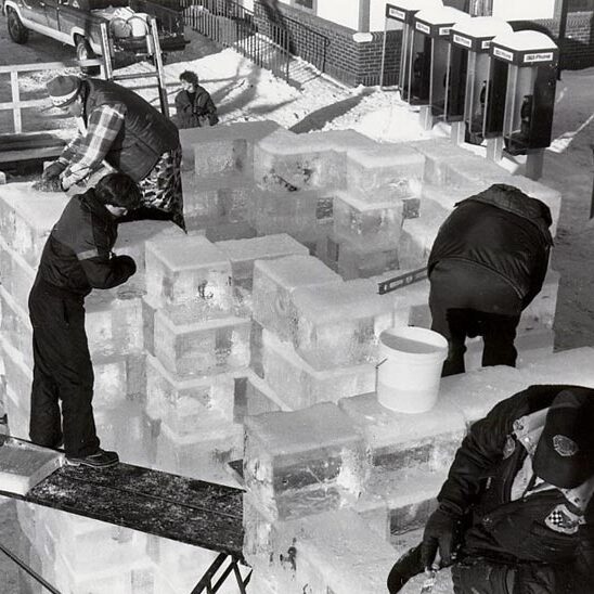 A group of men working on an ice sculpture.