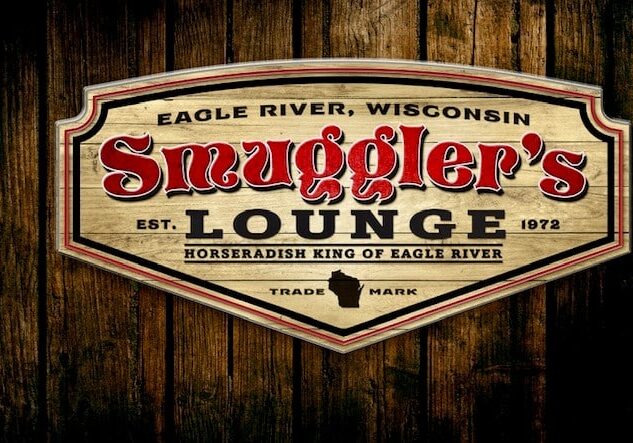 A wooden sign for Smuggler's Lounge in Eagle River, Wisconsin, established 1972, labeled as the Horseradish King of Eagle River.