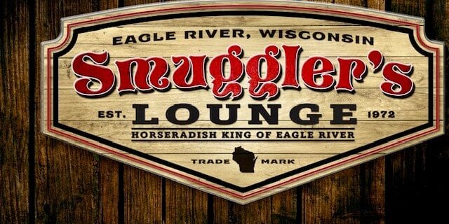 A wooden sign for Smuggler's Lounge in Eagle River, Wisconsin, established 1972, labeled as the Horseradish King of Eagle River.