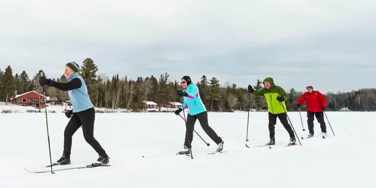 A group of people cross country skiing in the snow.